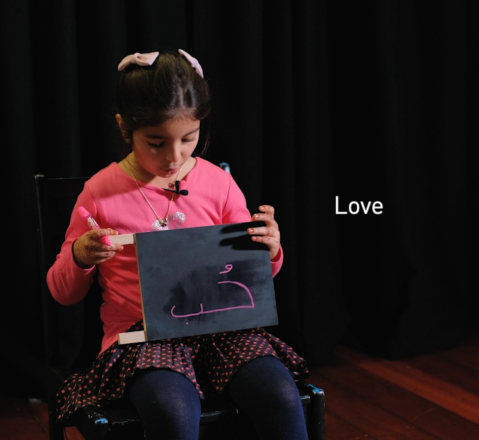 Child holding chalkboard.