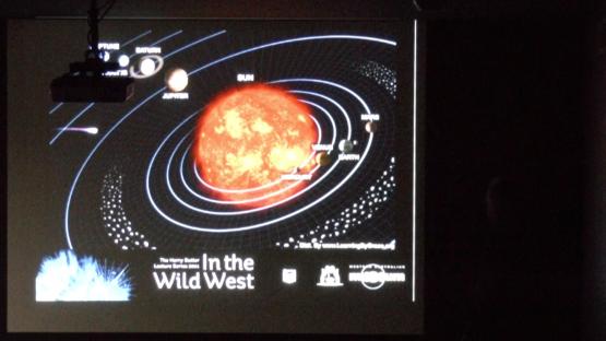 The origin and evolution of the Solar System - A slide from Alex Bevan's presentation who is standing to the right but in total darkness