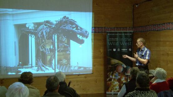 Dinosaurs of the 21st Century: masters of the sky - Mikael Siversson presenting a slideshow with a slide of a T-Rex fossil