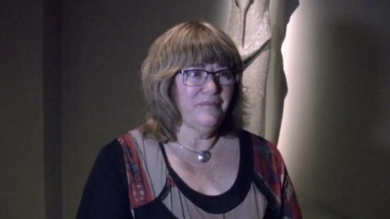 Moya Smith on Secrets of the Afterlife - Dr Moya Smith standing in front of a Egyptian statue