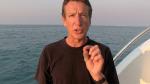 Clay Bryce with the ocean behind him talking to camera  