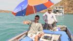 Rodrigo on a small dingy with using the Darlek to capture information from the sea under an umbrella  