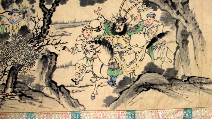 The reverse side of the banner features brush paintings. Chinese brush painting on the reverse side of a banner shows men at war.