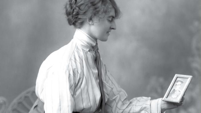 Faces from the front - Image copyright WA Museum A women holding an image of a solider relative
