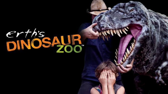 Dinosaur Zoo A man holding open T-rex jaws and a child with their eyes covered.