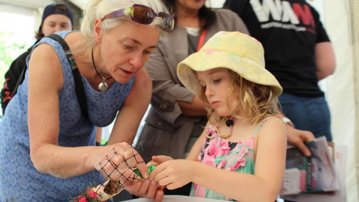 Caption: Community engagement with the WA Museum. "A woman and child building a coral reef from recycled material at AwesomeFest."
