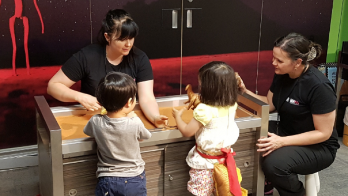 Activities at the WA Museum Discovery Zone Museum staff interacting with two children at the Discovery Zone.