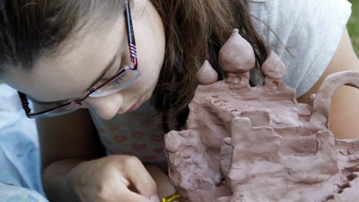 Mud Island "Young woman sculpting mud"