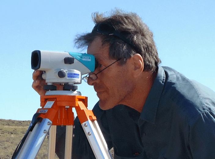 Bill Humphreys measuring the landscape with a surveying tool