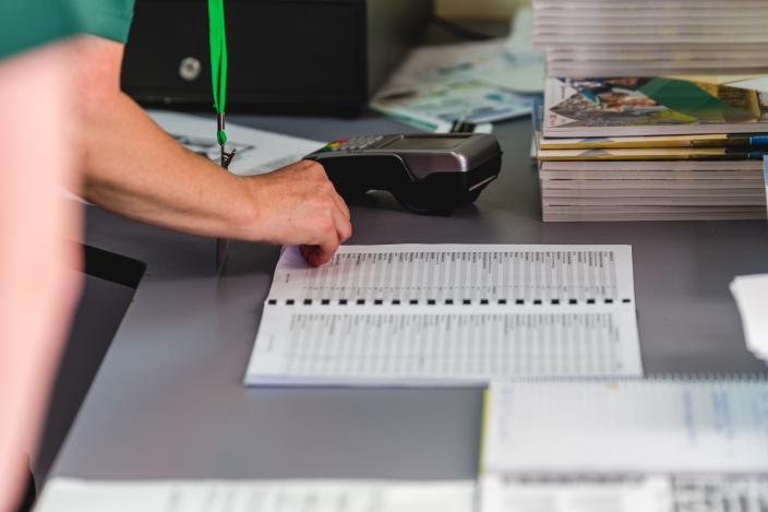 A volunteer signs in their hours in the log book