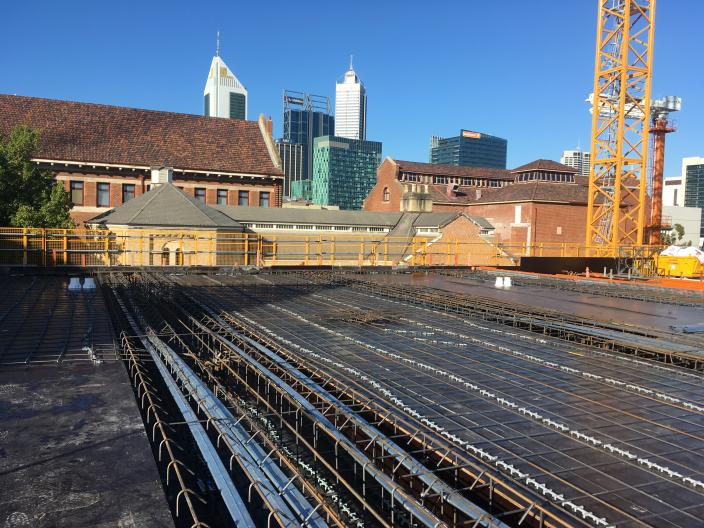 Lengths of steel reinforced bar laying across upper level floor