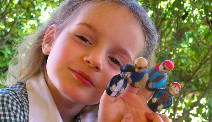 Caption: A young school child with pirate finger puppets.
