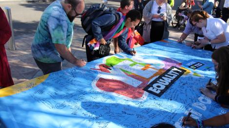 People sign a giant marriage equality banner