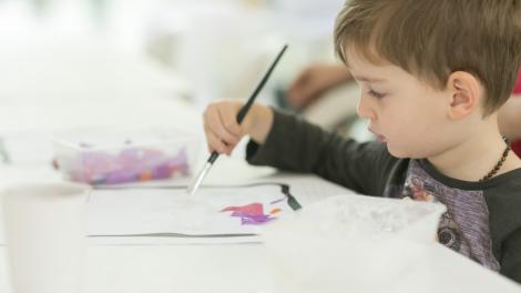Museum of Us Child painting a collage in the Museum of Us