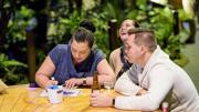 "Three friends are enjoying a drink while having fun with one of the exhibition's drawing interactive screens."