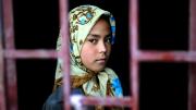 A small Afghan child viewed through a window