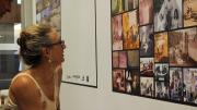 A woman kneels to look more closely at photographs on display on the wall of the Memory Room