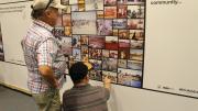 Two men inspect wall display of images of Exmouth's early days