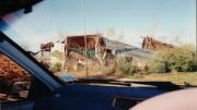 image shows view through car window screen of damage to a business yard.