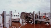 image shows a boat at harbour, tipped on it's side in the water.