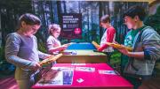 Dinosaur Discovery: Lost Creatures of the Cretaceous - Perth 2014 Four children stood around a table laughing and talking while completing a dinosaur activity on digital tablets.