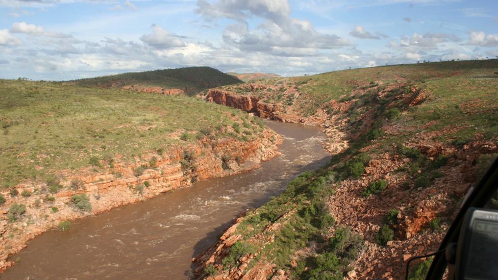 Rushing river running through a lanscape of massive burning red rocks