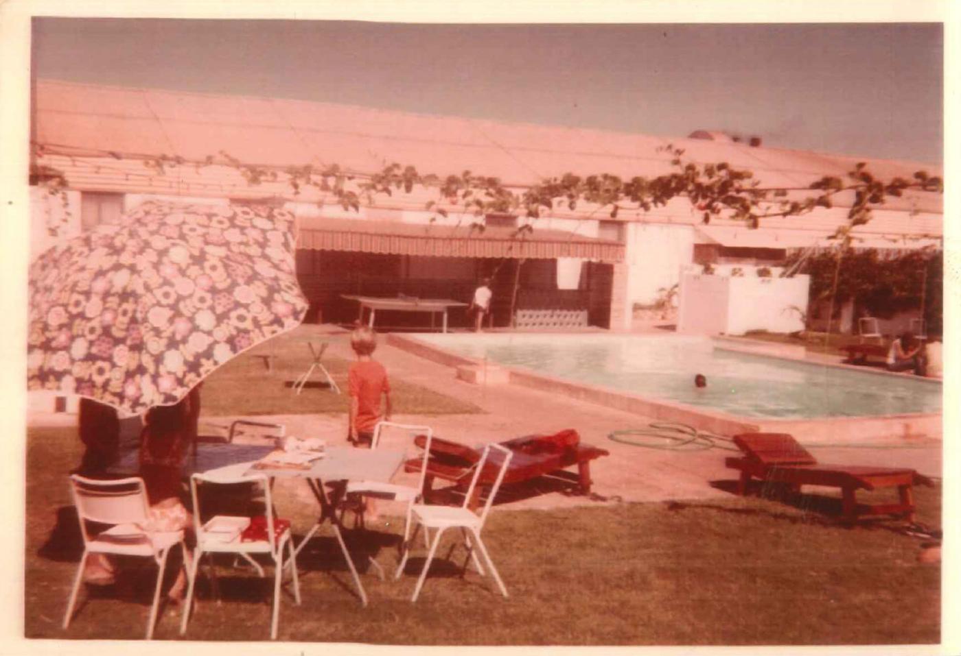 pool area of 1960s holiday lodge shows holiday makers relaxing by the pool - 1