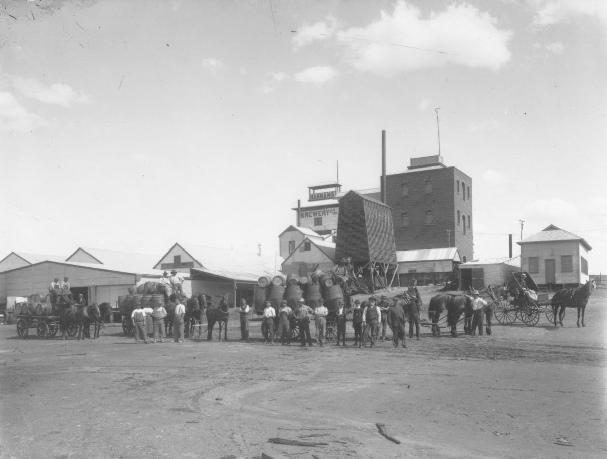 Horse drawn wagons loaded with beer barrels outside Hannan's Brewery Buildings, groups of men standing in front of wagons. Opening(Dwyer register).