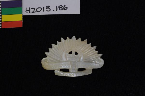 BADGE, carved pearlshell depicting rising sun cockade