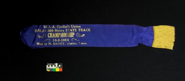 SASH, cycling, blue/gold, 'W.A.A. CYCLISTS UNION SENIOR 500M CHAMPIONSHIP', 10 February 1954, Noel Davy