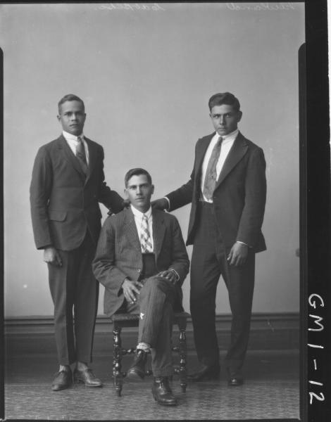 Portrait of three young men in suits, F/L 'Newland', one sitting on chair other standing.