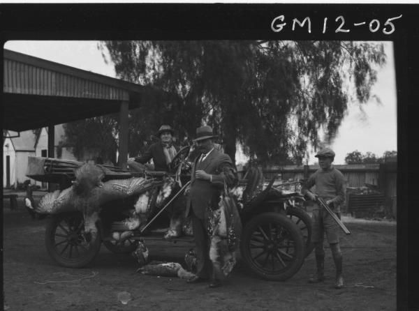 Three men in open car showing their catch of Wild Turkeys, 'Duff'