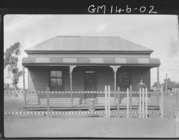 Man standing on verandah of house 'Carson'