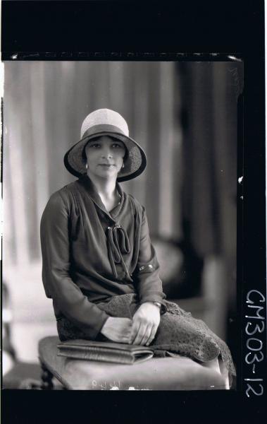 1/2 Portrait of woman, seated, wearing blouse, skirt, hat; 'Sloan'