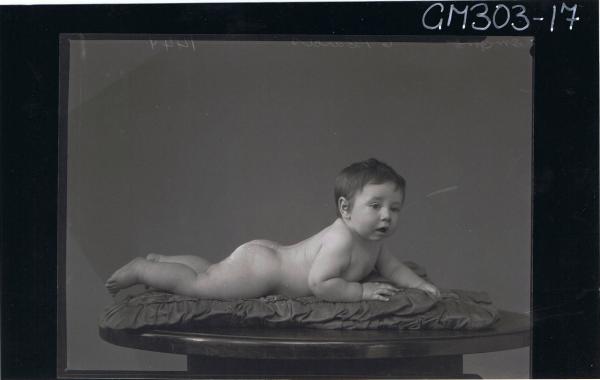 F/L Portrait of naked baby lying on table; 'Smythe'
