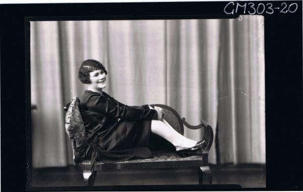 F/L Portrait of woman wearing satin dress, seated on lounge, 'St John'