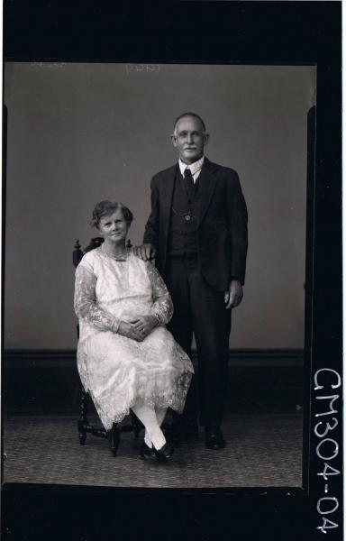 F/L Portrait of man standing wearing three piece suit, woman seated wearing three quarter length lace dress; 'Scott'