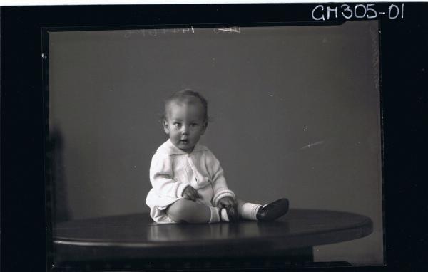 F/L Portrait of baby seated on table wearing cardigan; 'Shacklock'