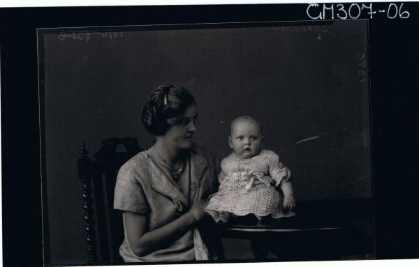 1/2 Portrait of woman seated, with baby seated on table; 'Schliker'