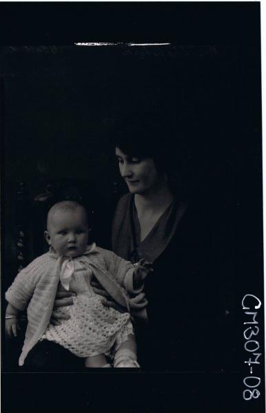3/4 Portrait of woman seated, holding a baby, wearing dress & cardigan; 'Mrs Sheppard'
