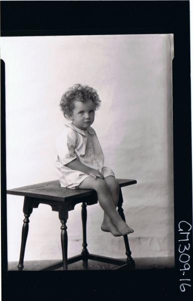 F/L Portrait of child seated on table wearing shirt; 'O'Dea'