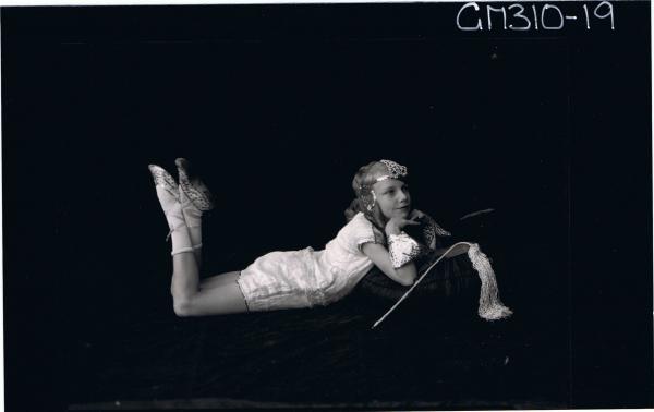 F/L Portrait of girl lying on floor wearing fancy dress costume, arranged for photographs; 'McLeod'