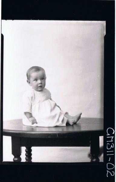 F/L Portrait of baby seated on table, wearing long dress; 'O'Dea'