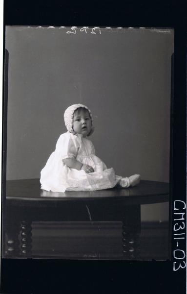 F/L Portrait of baby seated on table wearing lace dress, booties and bonnet; 'Markham'