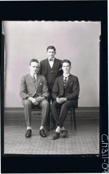 F/L Portrait of two men seated wearing suits, man standing wearing three piece suit; 'McQuoid'