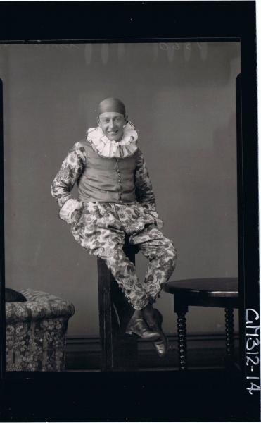 F/L Portrait of man seated on pillar wearing clown fancy dress costume 'Smith'