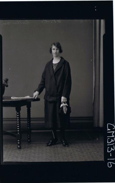 3/4 Portrait of woman seated,wearing three quarter length skirt and matching jacket,holding gloves & handbag 'Sullivan'