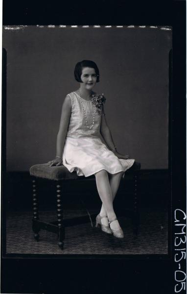 F/L Portrait of woman seated wearing satin knee length dress and corsage 'Michell'