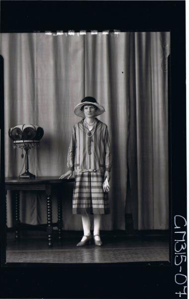 F/L Portrait of woman standing wearing 3/4 length striped day dress and hat, holding gloves 'Meyer'