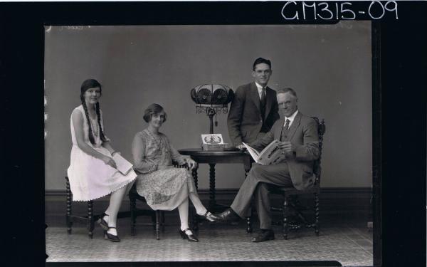 F/L Family Portrait of man seated wearing 3 piece suit,holding a book, 2 women seated, young man seated on table'Murray'